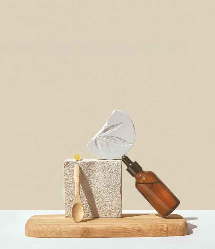 Divers produits aux CBD sur une planche avec un fond Beige